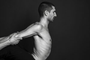 Hyacinthos guiding a client through a supported arm movement during Sotai bodywork.